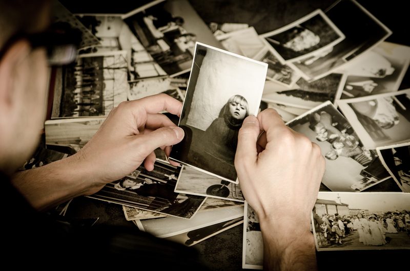 Albums de photos de famille à numériser, anciennes photos étalées sur une table